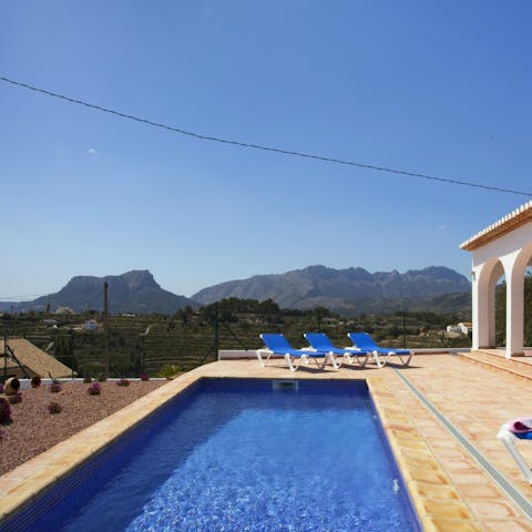 Spend lazy days relaxing by the pool with a view of the native plants, mountain range, and Mediterranean Sea