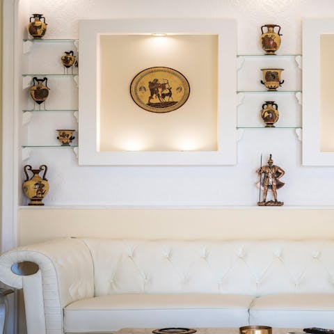 Admire the mosaic plates and urns, an ode to ancient Greece