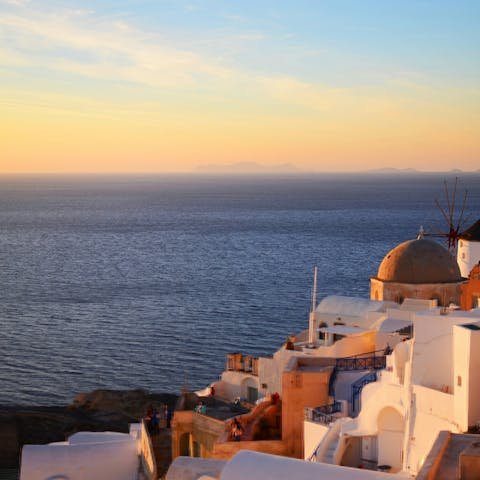 Watch the sunset over Oia's blue-roofed buildings