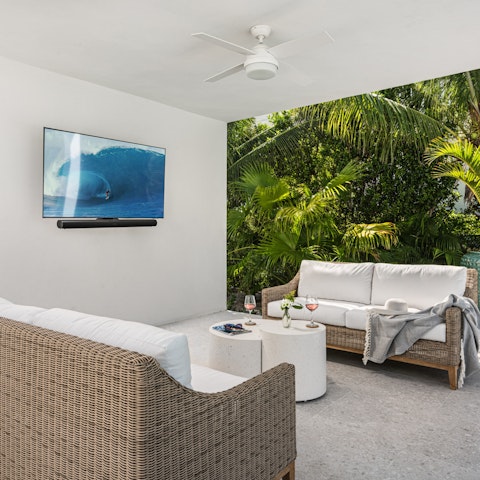 Watch your favourite movies on the wall-mounted TV in the outdoor lounge area