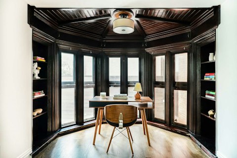 Work or read surrounded by rich dark woodwork and built-in shelves