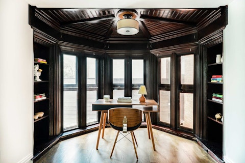 Work or read surrounded by rich dark woodwork and built-in shelves