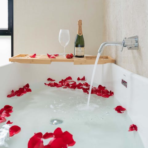 Treat yourself to an indulgent bubble bath in the sleek bathroom