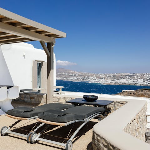 Take in views of Mykonos Chora from the sun loungers
