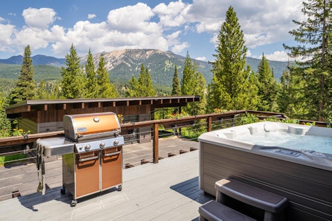Soak in the hot tub with mountain peaks stretching behind you