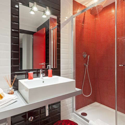 Start mornings with a relaxing soak under the red bathroom's rainfall shower