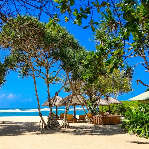 Explore the rolling green countryside volcanic beaches of Batu Belig