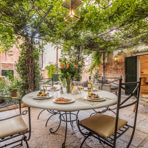 Sit down to a celebratory alfresco meal beneath the vine-covered pergola