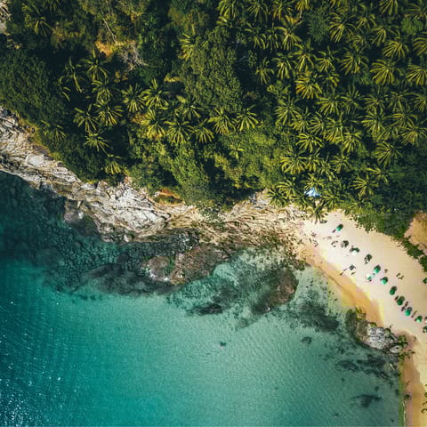 Cool off in the turquoise waters of Surin Beach, a twelve-minute walk from home