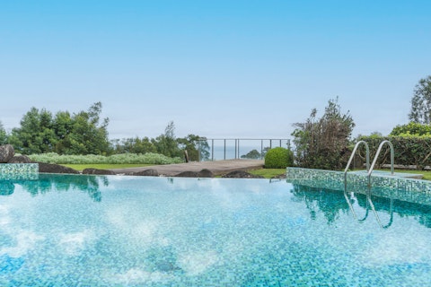 Cool off with a dip in the swimming pool, surrounded by lush gardens