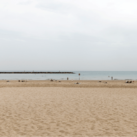 Stretch out on the golden sands of Frishman Beach