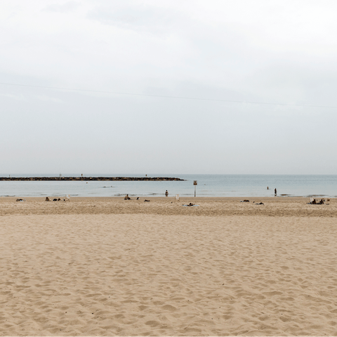 Stretch out on the golden sands of Frishman Beach