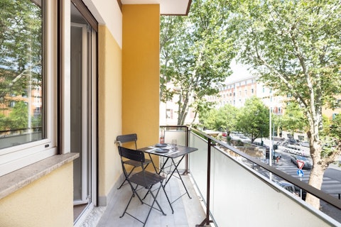 Take breakfast on the balcony as the city wakes up, shaded by tall trees