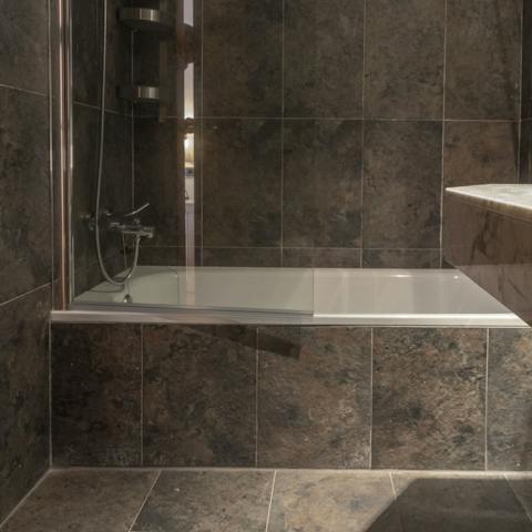Chill out in the black-tiled bathtub