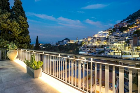 Watch the town light up across the hillside at dusk