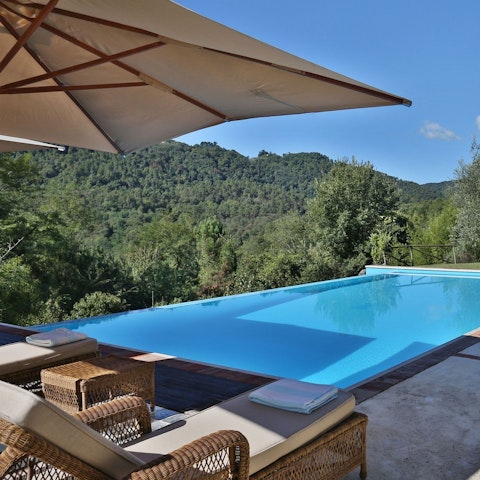 Stretch out by the pool with views across forested hills