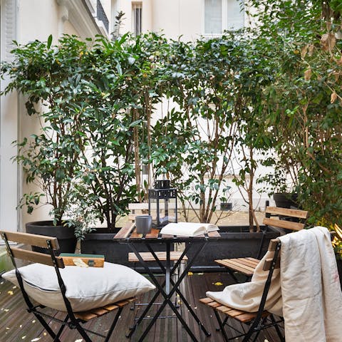 Enjoy a glass of Champagne on the leafy terrace