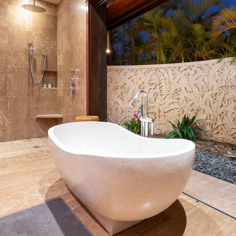 Soak in the freestanding tub as a tropical breeze drifts through the bathroom