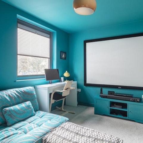 Turn your evening into a movie night with the second bedroom's cinema setup