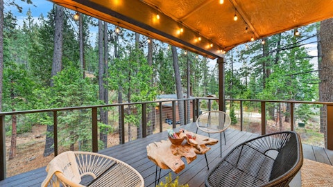 Settle into the covered deck as the pine trees close in around you