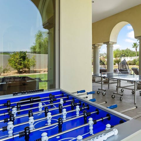 Play foosball with the tranquil setting of the garden in the background