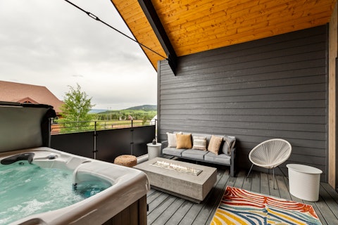 Soak in the hot tub with rolling mountain views beyond
