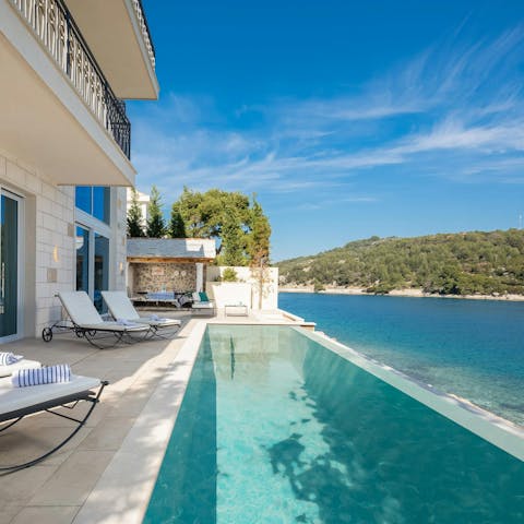 Swim in the infinity pool with a panoramic ocean view