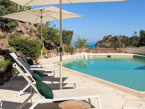 Stretch out beside the pool as the sea glitters beyond
