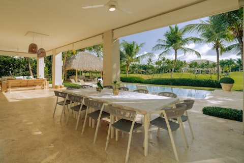 Dine poolside with palm trees beyond