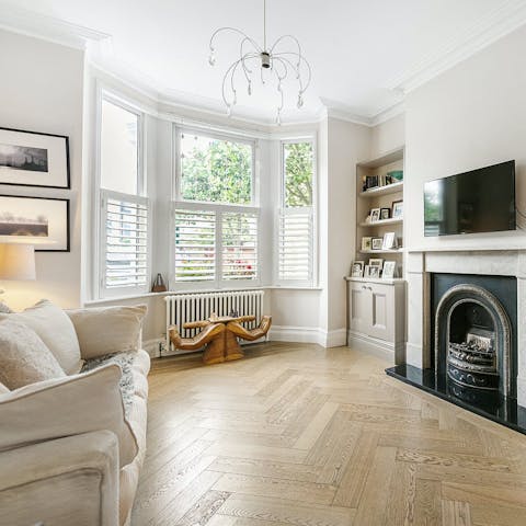 Admire the parquet flooring, period fireplace and bay window
