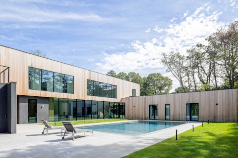 Swim laps in a sleek pool wrapped by woodland