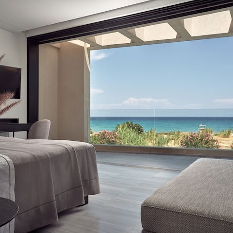 Wake to the sight of a shimmering blue sea from walls of glass