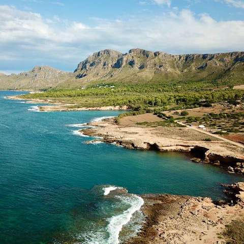 Discover the warm sandy shores of Cala San Vicente, just 7km away