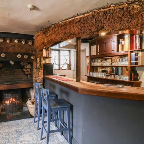Pour a drink at the private bar with an open fire