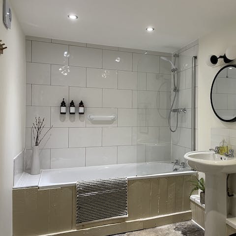Treat yourself to an indulgent soak in the smartly tiled bathtub