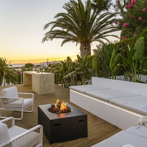 Watch the sunset over the horizon while cosying up by the outdoor fire