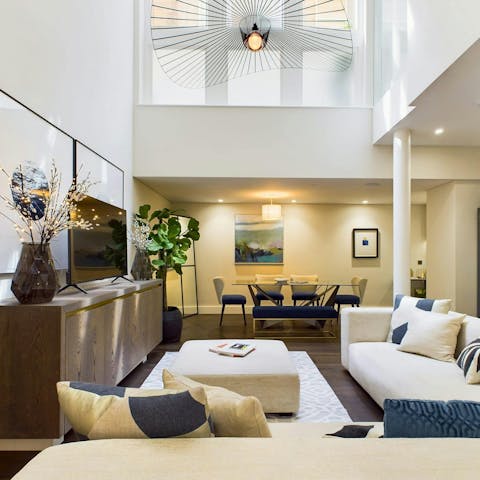 Relax in the light-filled living space with its double-height ceiling