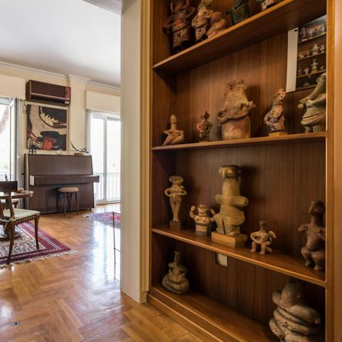 Admire the extensive collection of artwork on the shelves and walls