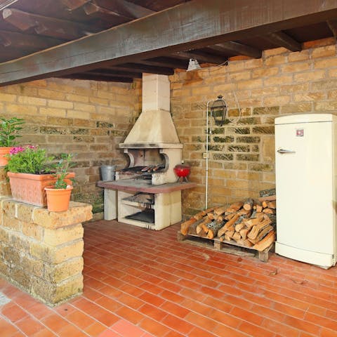 Cook on the traditional log-fired barbecue in the outdoor kitchen