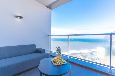 Take breakfast above the beach as sailboats drift past