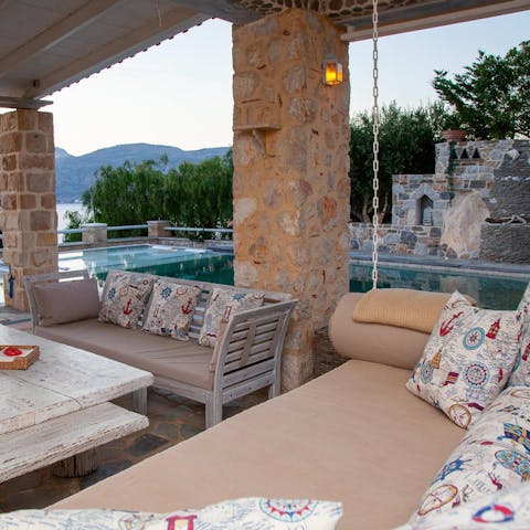 Sip on a cocktail on the outdoor sofas when the sun sets behind the trees