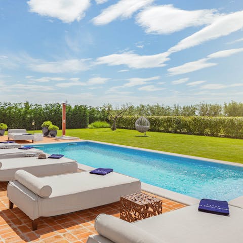 Sunbathe on one of the luxury beds by the swimming pool