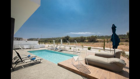 Unwind poolside beneath wide-open Cypriot skies