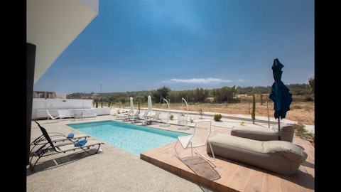 Unwind poolside beneath wide-open Cypriot skies