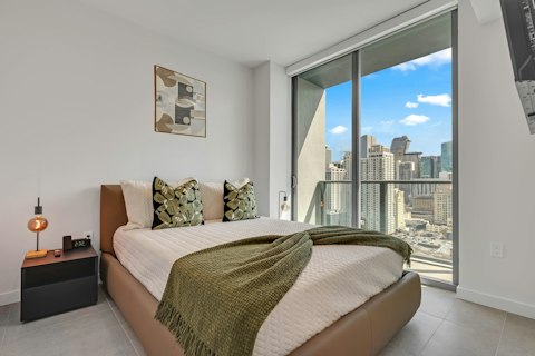 Rest in a bedroom wrapped in floor-to-ceiling windows and sweeping Miami skyline views