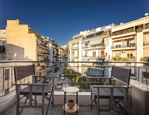 Enjoy a glass of wine on the balcony, perched above the Athens streets