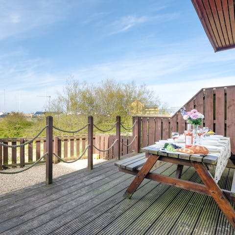 Admire the boats in the marina from the picnic bench on deck