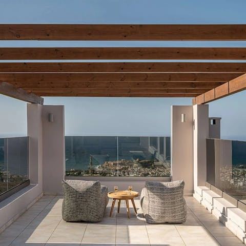Share a bottle of Greek wine as you soak up sea views from the rooftop terrace