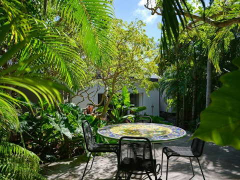 Take breakfast in the garden surrounded by vibrant tropical greenery