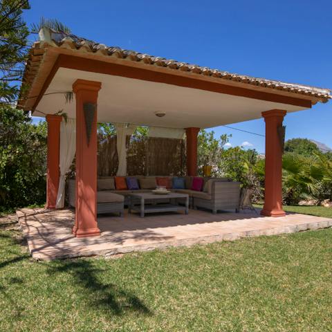 Relax under the towering stone pergola